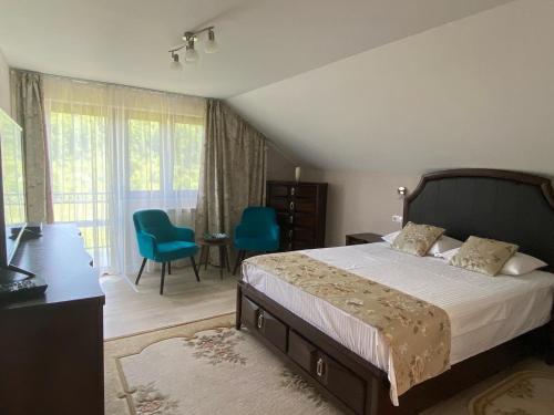 a bedroom with a bed and a table and chairs at Pensiunea Ivoire in Avrig