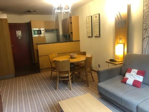 un salon avec un canapé et une table et une cuisine dans l'établissement Appartement 2P avec Balcon, Piscine, Sauna et Parking - Pied des Pistes Arc 1800 - FR-1-346-318, à Arc 1800