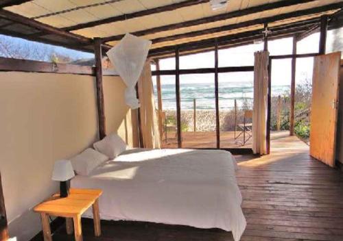 a bedroom with a bed and a view of the ocean at Underwater Explorer in Ponta do Ouro