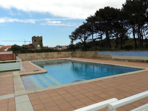 ein großer Pool mit einer Steinmauer um ihn herum in der Unterkunft Apartamento con piscina a escasos metros de A Lanzada in Pontevedra