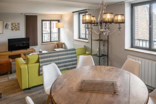 a living room with a wooden table and chairs at LOGIS Hotel-Restaurant Le Relais d'Aligre in Châteauneuf-en-Thymerais