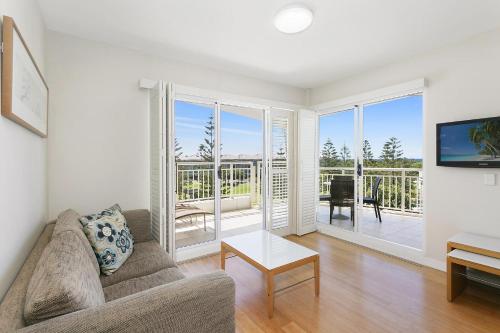 a living room with a couch and a table at Mantra on Salt Beach - Oceanview Apartment by uHoliday - 2BR, 1BR and Hotel Room configurations available in Kingscliff
