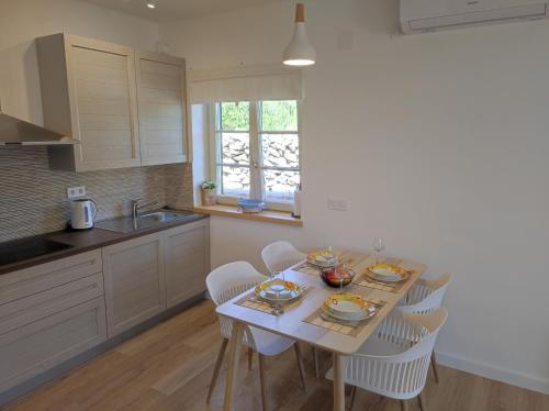 a kitchen with a table with chairs and a sink at LOVRO Luxury apartment with terrace sea view in Sali