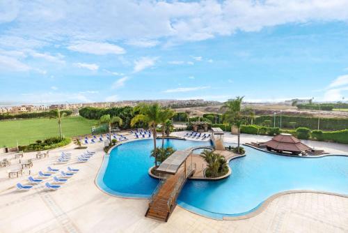 a resort with a swimming pool and lounge chairs at Radisson Blu Hotel Alexandria in Alexandria