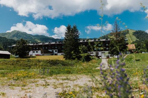 a group of buildings in a field with mountains in the background at Hotel Enzo Moro in Sùtrio