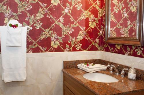 a bathroom with a sink and a red wall at Polkerris Bed & Breakfast in Montego Bay