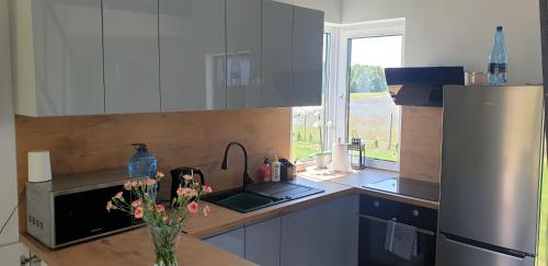 a kitchen with a vase of flowers on a counter at Wierzchy 34 in Wierzchy