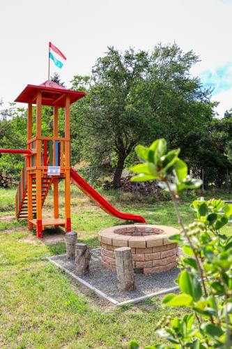 a playground with a red slide and a play structure at Fűszeres Porta in Mihályfa