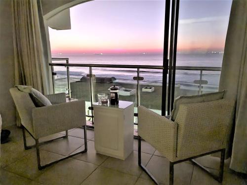 a room with two chairs and a view of the ocean at 405 Bermudas - by Stay in Umhlanga in Durban