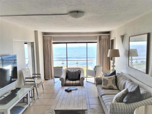 a living room with a couch and a view of the ocean at 405 Bermudas - by Stay in Umhlanga in Durban