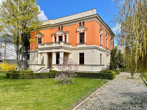 Casa grande de color naranja y blanco con patio en Happy Living Villa, en Wroclaw