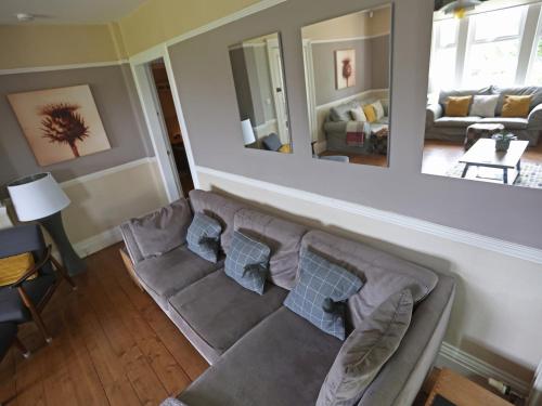 a living room with a couch and a mirror at Roseburn in Pitlochry