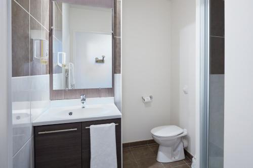 a bathroom with a sink and a toilet at Aparthotel Adagio Access Poitiers in Poitiers