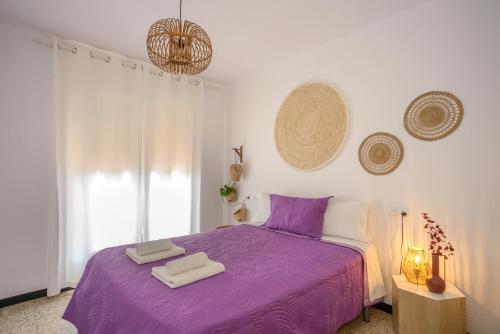 エンプリアブラバにあるEmpuriabrava Apartaments - nº7のベッドルーム1室(紫色のベッド1台、タオル2枚付)