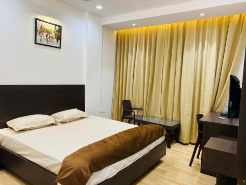 a bedroom with a bed and a desk and a television at Shivanand Residency in Jejūri