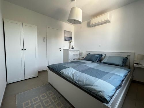 a bedroom with a large bed with blue sheets at Apartman Ana in Sveti Anton
