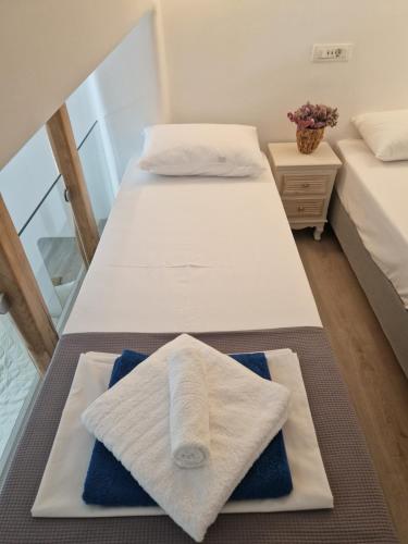 two beds in a room with towels on them at Empyreal Blue Apartments in Dexamenes
