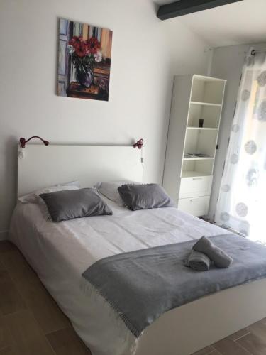 - une chambre avec un grand lit blanc dans l'établissement Studio L Oustaou, à Marseille