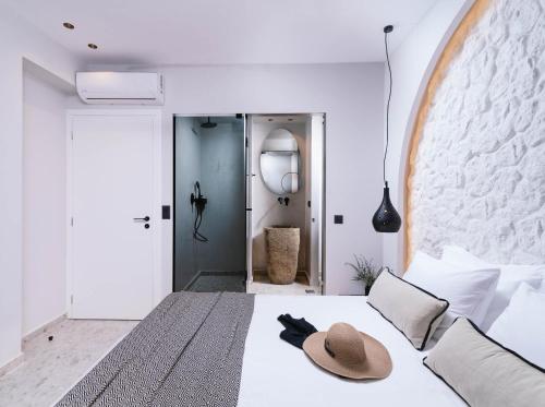 a bedroom with a bed with a hat on it at Kedros Katikies in Kalamaki Heraklion