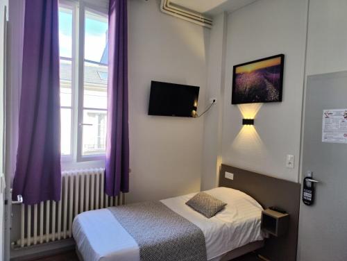 a bedroom with a bed and a window with purple curtains at Hotel Des Lices - Angers in Angers
