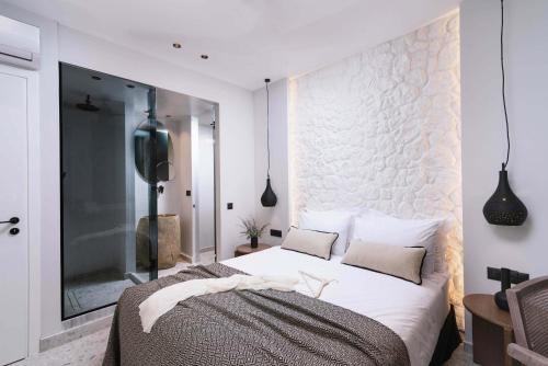 a bedroom with a large bed with white walls at Kedros Katikies in Kalamaki Heraklion