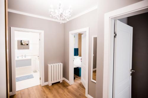 una camera con lampadario a braccio e porta bianca di Mon Jardin Apartment a Cluj-Napoca