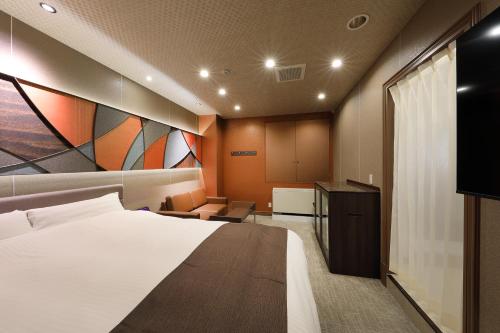 um quarto de hotel com uma cama e uma televisão de ecrã plano em ホテルバースデー岐阜西店 HOTEL Birthday GifuWest em Gifu