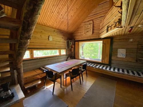 a dining room with a table and chairs in a cabin at Loma-asunto tunturimaisemassa in Ylikyro