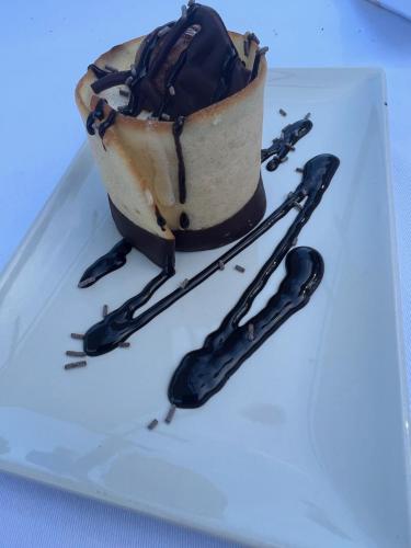 a chocolate dessert on a white plate with tongs at Hotel El Cisne in Zaragoza