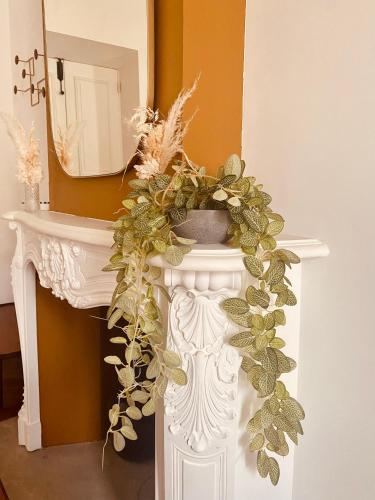 une console blanche avec une couronne sur celle-ci dans l'établissement Appartement de maître T3 80m2 en plein centre., à Ajaccio