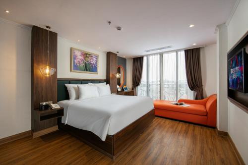 a bedroom with a large bed and an orange couch at Bendecir Hotel & Spa in Hanoi