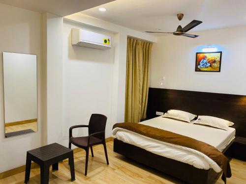 a bedroom with a bed and a chair in it at Shivanand Residency in Jejūri