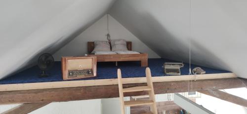 Zimmer mit einem Bett und einem Stuhl im Dachgeschoss in der Unterkunft zentrumsnahes Wohnen in der Alten Schule am See in Schwerin