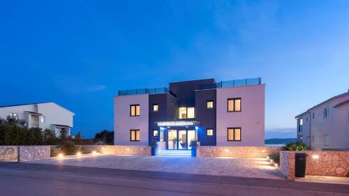 a house with a blue door at night at Villa Ivan in Sveti Filip i Jakov