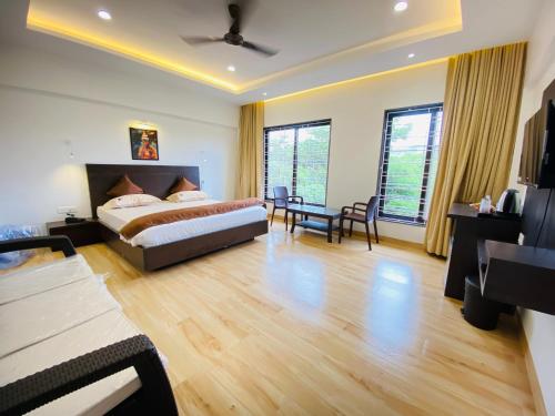 a bedroom with a bed and a table and chairs at Shivanand Residency in Jejūri