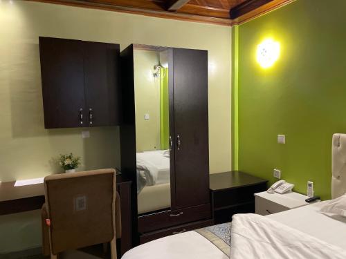 a room with a bedroom with a mirror and a bed at United Hotel in Mbankomo