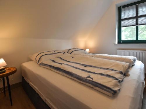 a bed with a blanket on it in a room at Ferienwohnung Hugo nur 200 Meter bis zum Wasser in Putbus