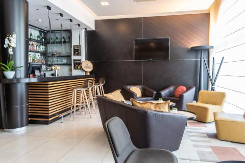 eine Bar in einem Restaurant mit Stühlen und einer Theke in der Unterkunft Novotel Brussels Centre Midi in Brüssel