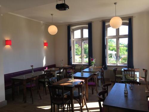 - une salle à manger avec des tables, des chaises et des fenêtres dans l'établissement Gutshaus Lexow, à Lexow