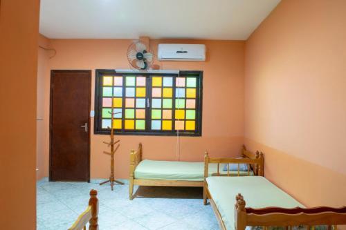 Habitación con 2 camas y vidriera. en OYO Pousada Simone, en Itaboraí