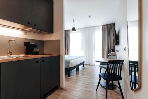 une chambre avec une cuisine et une chambre avec un lit dans l'établissement Appart'City Collection Saint Germain en Laye, à Saint-Germain-en-Laye