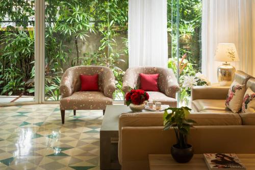 a living room with two chairs and a couch at El Sereno 2 BHK Stylish Apartments In Vagator with Garden and Pool- 10 minutes drive to Vagator Beach in Chapora