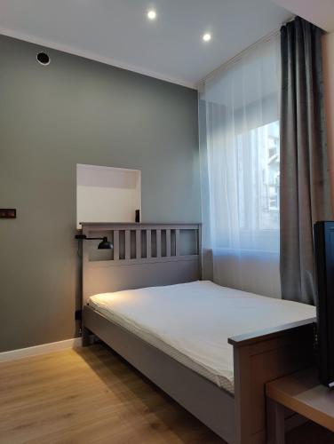a bedroom with a large bed with a window at Apartament Szczecin in Szczecin