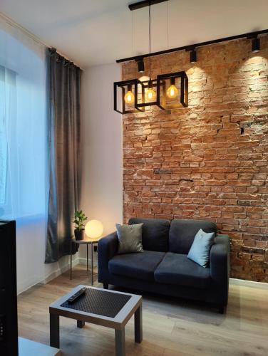 a living room with a couch and a brick wall at Apartament Szczecin in Szczecin