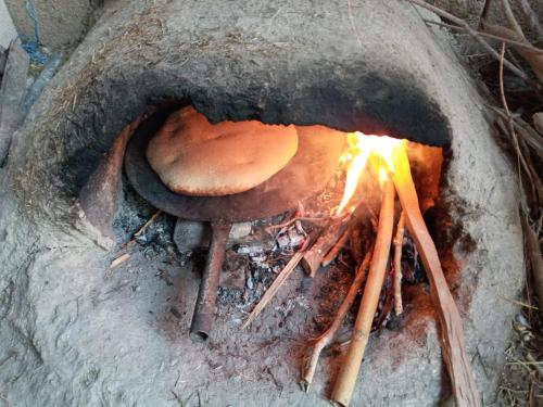 um cogumelo está a cozinhar num forno a lenha em Auberge des lacs em Imilchil