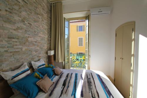 1 dormitorio con 1 cama con pared de ladrillo en Nice Massena, en Niza