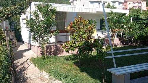 a bench in front of a house with trees at Sea Cottage Studios in Budva