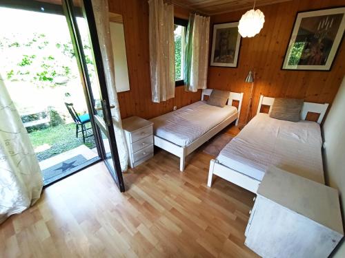 sypialnia z 2 łóżkami i przesuwnymi szklanymi drzwiami w obiekcie Tara w Wiśle