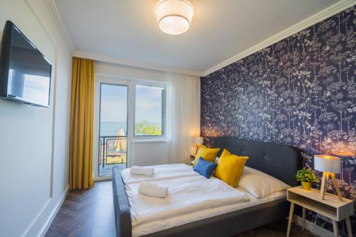 1 dormitorio con 1 cama grande con almohadas amarillas y azules en Anna Beach Villa, en Siófok