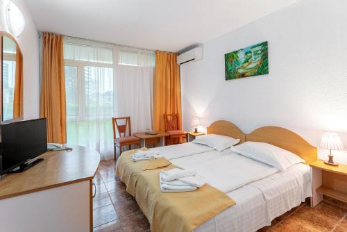 a bedroom with two beds and a flat screen tv at Hotel Cerna in Saturn